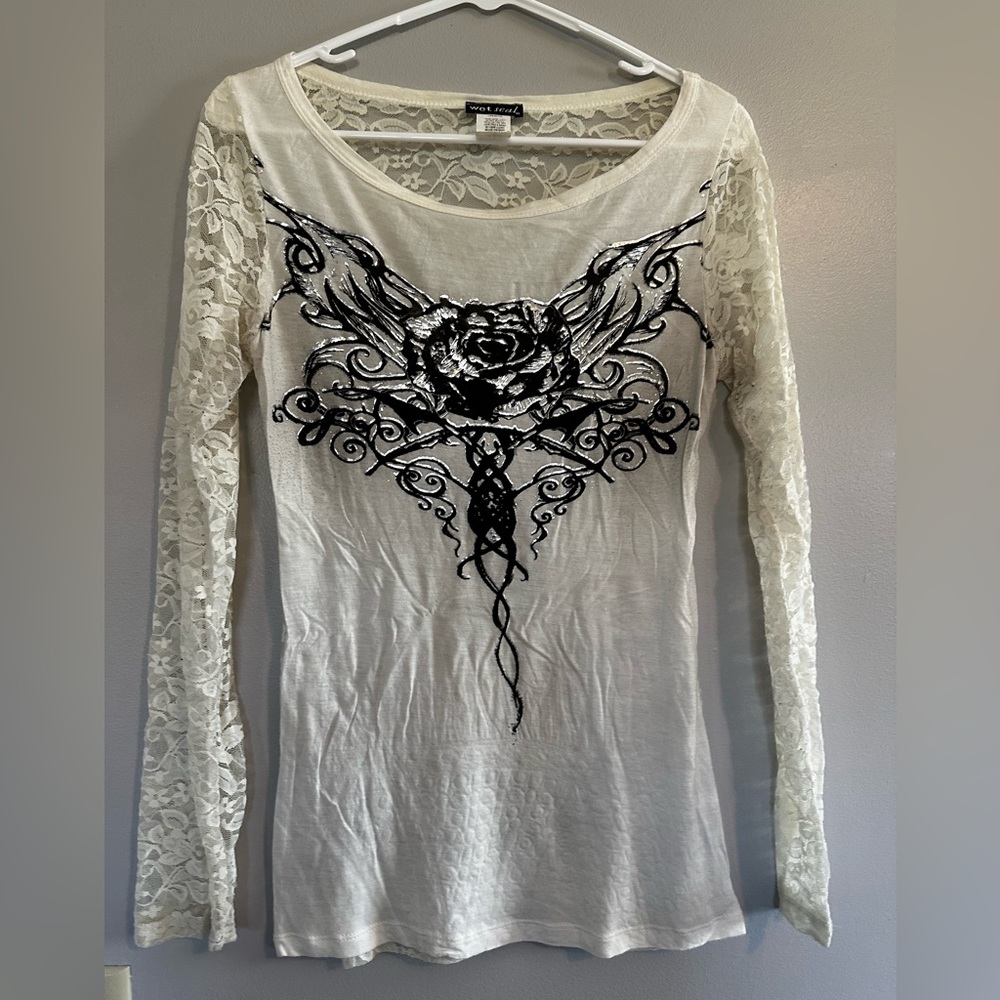 Cream shirt with lace arms, lace back, with a rose and wings design on front.